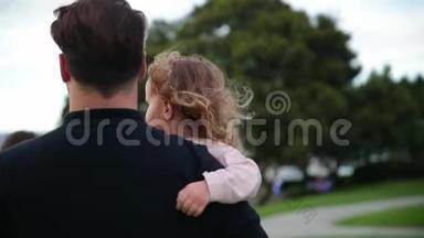 <strong>女儿</strong>坐在<strong>父亲</strong>的手上。 <strong>女儿</strong>拥抱<strong>父亲</strong>，笑了。 他们一起在户外散步。